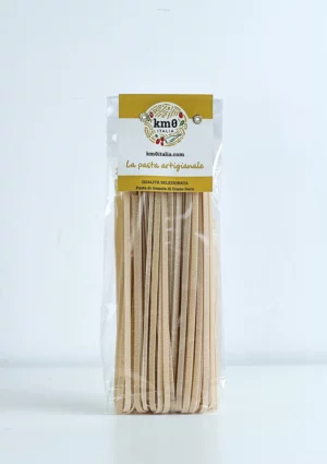 Tagliatelle artigianali Km0italia trafilate al bronzo in primo piano, ideali per ragù e sughi della tradizione italiana.